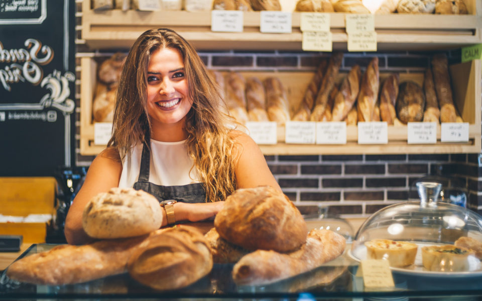 Junge Frau in der Bäckerei mit Dinapay, dem Kassensystem für deine Bäckerei